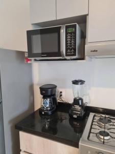 a kitchen counter with a microwave and a blender at Departamento con vista increíble en piso 16 in Guadalajara