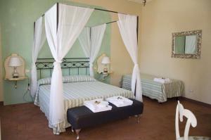 a bedroom with two beds and a canopy bed at B&B Anfiteatro in Lucca