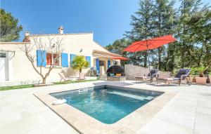 Casa con piscina y sombrilla roja en Gorgeous Home In Poulx With Wifi, en Poulx