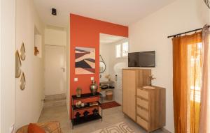 a living room with an orange accent wall at Gorgeous Home In Poulx With Wifi in Poulx