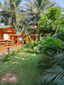 a yard with a house and some palm trees at Aquila Boutique Resort Agonda in Canacona