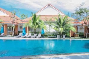 a swimming pool in front of a house with palm trees at Sea Breeze Hotel & Villa in Sihanoukville