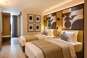 una habitación de hotel con 2 camas en una habitación en Parallel Hotel Udaipur - A Stylish Urban Oasis, en Udaipur