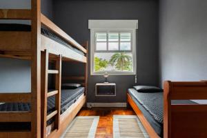 a bedroom with two bunk beds and a window at Tacos da Enseada in Guarujá