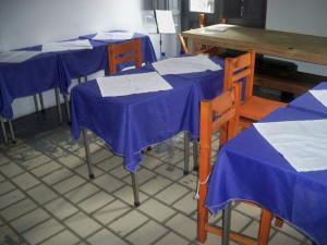 a row of tables and chairs with blue and white table cloth at CasaHostel in Buenos Aires