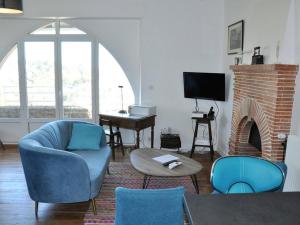 uma sala de estar com cadeiras azuis e uma lareira em Maison Perros-Guirec, 4 pièces, 5 personnes - FR-1-368-42 em Perros-Guirec