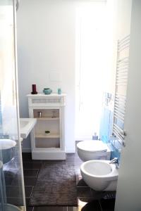 een witte badkamer met 2 wastafels en een toilet bij Nido Degli Angeli in Rome