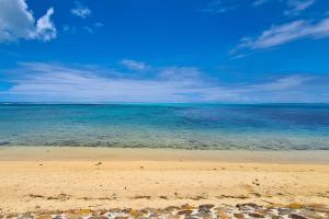 a beach with the ocean and a blue sky at Cottage Miti Reva in Haapiti