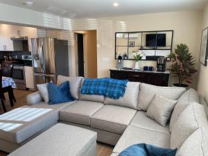 uma sala de estar com um sofá e uma cozinha em Bright poolside walkout two bedroom basement suite in the Okanagan em Penticton