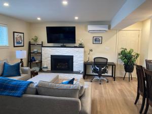 a living room with a couch and a fireplace at Bright poolside walkout two bedroom basement suite in the Okanagan in Penticton