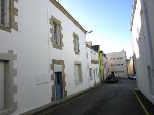 eine Gasse mit weißen Gebäuden und einem Auto auf der Straße in der Unterkunft Studio Étel, 1 pièce, 2 personnes - FR-1-479-93 in Étel