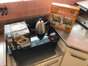 eine Küchentheke mit einer Teekanne und einer Schachtel in der Unterkunft GANADAN Cottage in Kagoshima