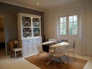a dining room with a table and chairs and a hutch at Villa Landaise Rénovée Proche Plages - Jardin et Terrasse Privatifs - FR-1-413-80 in Capbreton