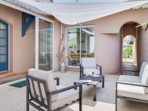 a patio with two chairs and a table at Villa confortable avec piscine, proche plage, 3 chambres, grand séjour, patio, WIFI, équipement complet - FR-1-413-87 in Capbreton +7 photos