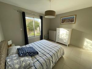 a bedroom with a bed and a dresser and a window at Appartement Capbreton, 2 pièces, 4 personnes - FR-1-413-133 in Capbreton