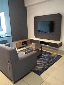 een woonkamer met een bank en een flatscreen-tv bij Hyve Soho Suite - Netflix in Cyberjaya
