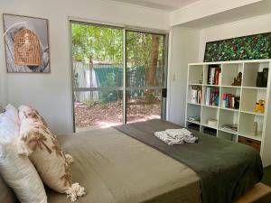 a bedroom with a bed and a large window at Jikinerita Homestay in Nelly Bay