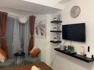 a living room with a flat screen tv on the wall at Comfy Condo Grand Riviera Suite, Roxas Blvd Ermita Manila infront of US Embassy in Manila