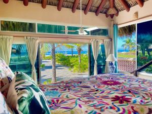 シワタネホにあるOceanfront Villa Zihuatanejoのビーチの景色を望むベッドルーム1室(ベッド1台付)