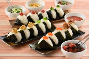 a table with plates of sushi and bowls of food at Kyukamura Noto-Chirihama in Hakui