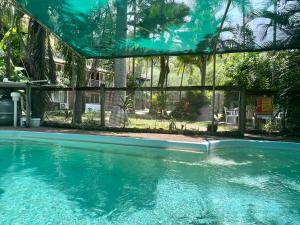 a swimming pool with a view of a house at Jikinerita Homestay in Nelly Bay