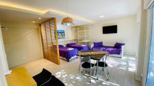 sala de estar con muebles de color púrpura y mesa en ALQUILER TEMPORARIO UNIVERSAL en Godoy Cruz