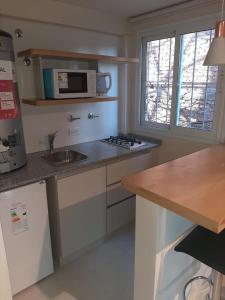 a kitchen with a sink and a microwave at DEPARTAMENTOS Alquiler Temporario UNIVERSAL in Godoy Cruz