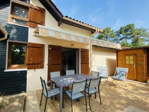 a patio with a table and chairs in front of a house at Villa Capbreton, 3 pièces, 4 personnes - FR-1-413-174 in Capbreton