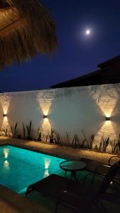a swimming pool at night with the moon in the background at BG Sol e Mar - Chalé Mar in Barra Grande