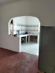 a kitchen with an arch in the middle of a room at Mambo Leo Hostel in Paje