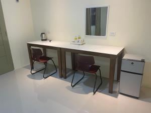 a desk with two chairs and a mirror in a room at Summer room B in Dumaguete