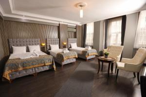 a hotel room with two beds and a chair at Cumbali Luxury Boutique Hotel in Istanbul