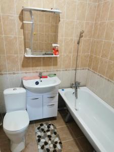 a bathroom with a toilet and a sink and a bath tub at Квартира in Atyraū