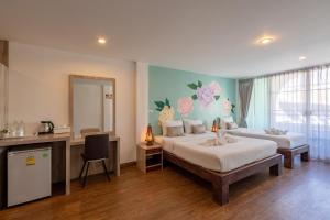 a bedroom with two beds and a desk and a mirror at B House Chiang Mai Thailand in Chiang Mai
