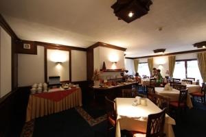 un restaurante con mesas y sillas y una persona de fondo en Hotel Petit Prince, en Antagnod