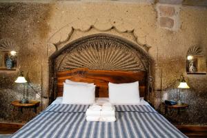 a bedroom with a bed with two towels on it at Goreme Suites by AZA in Göreme