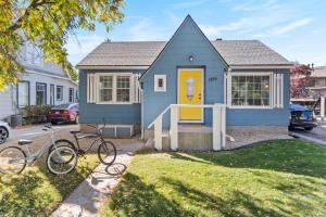 a blue house with a yellow door and two bikes at West End Stay in Boise