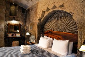 a bedroom with a large bed in a stone wall at Goreme Suites by AZA in Göreme