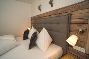 1 dormitorio con cama blanca y cabecero de madera en Ferienhof Stöckl en Finkenberg