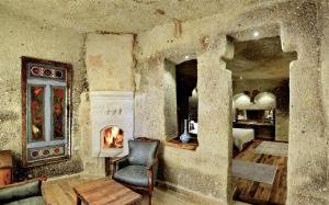 a living room with a fireplace and a chair at Goreme Suites by AZA in Göreme