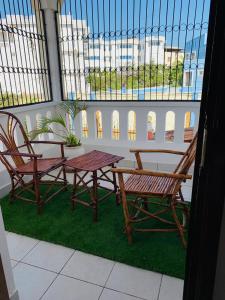 a table and two chairs on a balcony at Lux Suites Mahesh Doshi Apartments Nyali in Mombasa