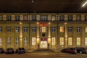 ein großes Gebäude mit davor geparkt in der Unterkunft ibis Karlsruhe Hauptbahnhof in Karlsruhe