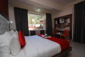 een slaapkamer met een bed met rode kussens en een raam bij Hotel yellow nest inn in Dharamshala