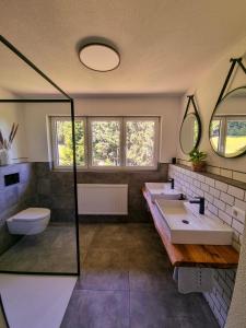 a bathroom with two sinks and a toilet at Ferienwohnung Holiswald in Oppenau