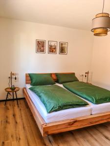 een slaapkamer met een bed met groene lakens bij Ferienwohnung Holiswald in Oppenau