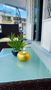 a yellow vase sitting on top of a glass table at Urban Zen Appart Spacieux studio atypique avec bain a remous proche de tout in Pointe-à-Pitre