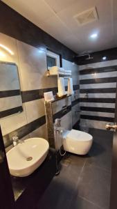 een badkamer met een witte wastafel en een toilet bij WOLKENBURG RESORT & SPA in Munnar