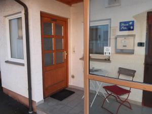 een deur naar een gebouw met een tafel en een stoel bij Landhaus-Stockinger in Büchlberg