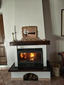 a fireplace in a living room with a fire at Teresa Belvedere Rooms&HolidayApartments Camere&Appartamenti in Castellinaldo