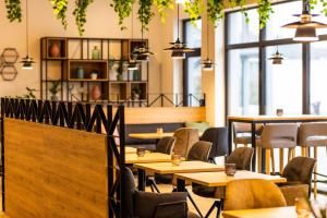 a restaurant with tables and chairs and windows at Point 7 Hotel in Fulda
